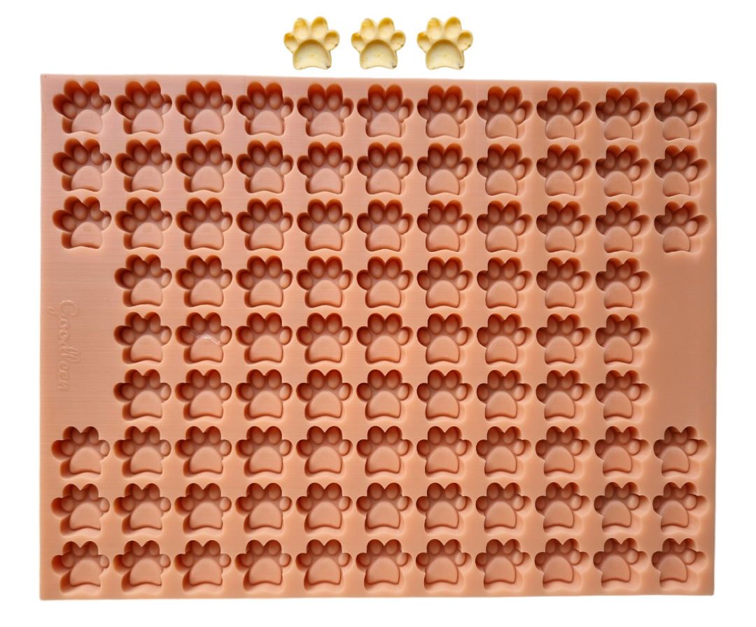 
„Silikon-Backmatte in Pfotenform mit zahlreichen kleinen Mulden in Form von Hundepfoten, ideal für selbstgemachte Hundeleckerlis, Modell von Goodleen.“