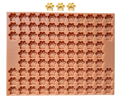 
„Silikon-Backmatte in Pfotenform mit zahlreichen kleinen Mulden in Form von Hundepfoten, ideal für selbstgemachte Hundeleckerlis, Modell von Goodleen.“